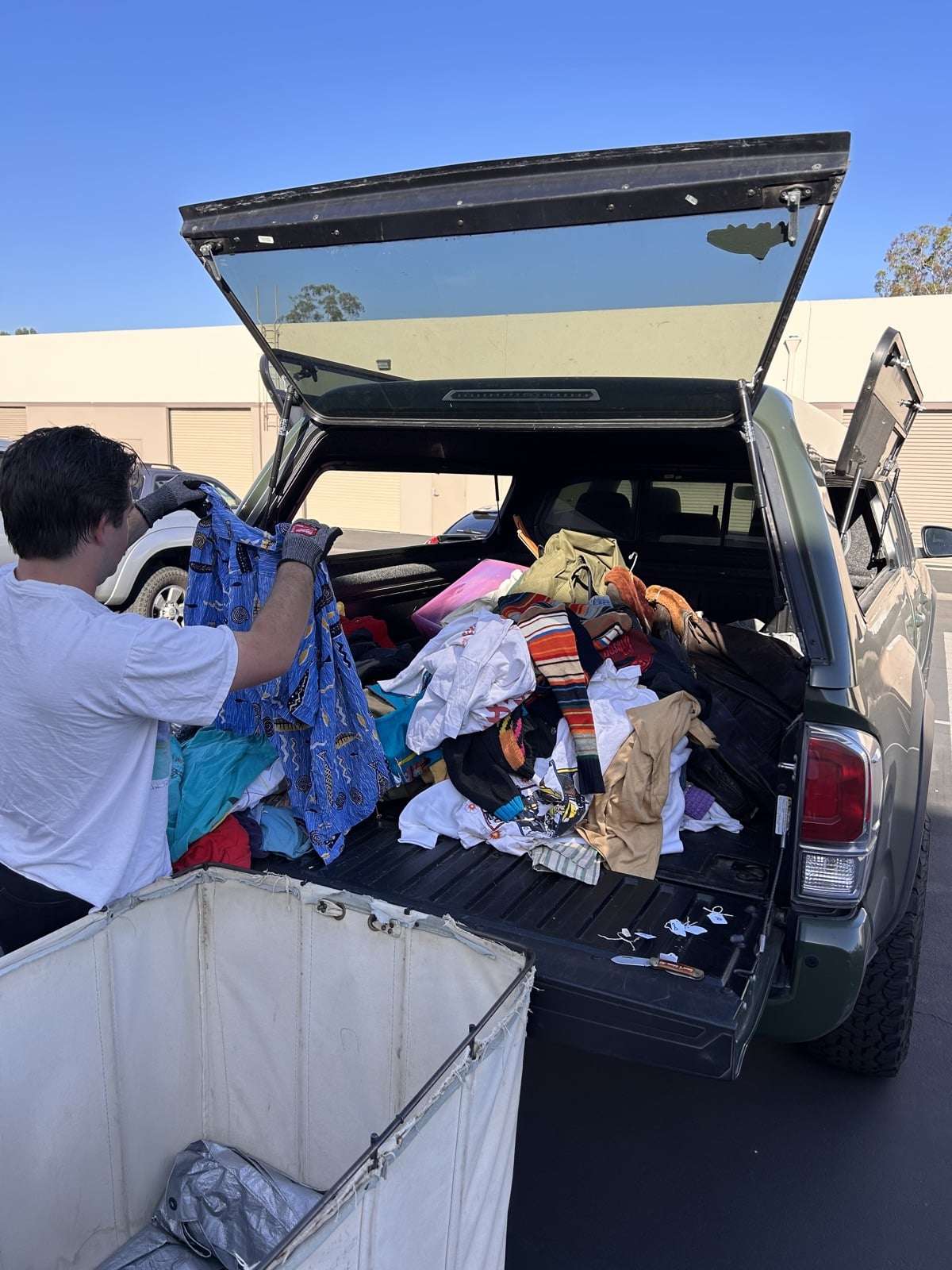 Loading a truck bed with vintage clothing at a Southern California house call