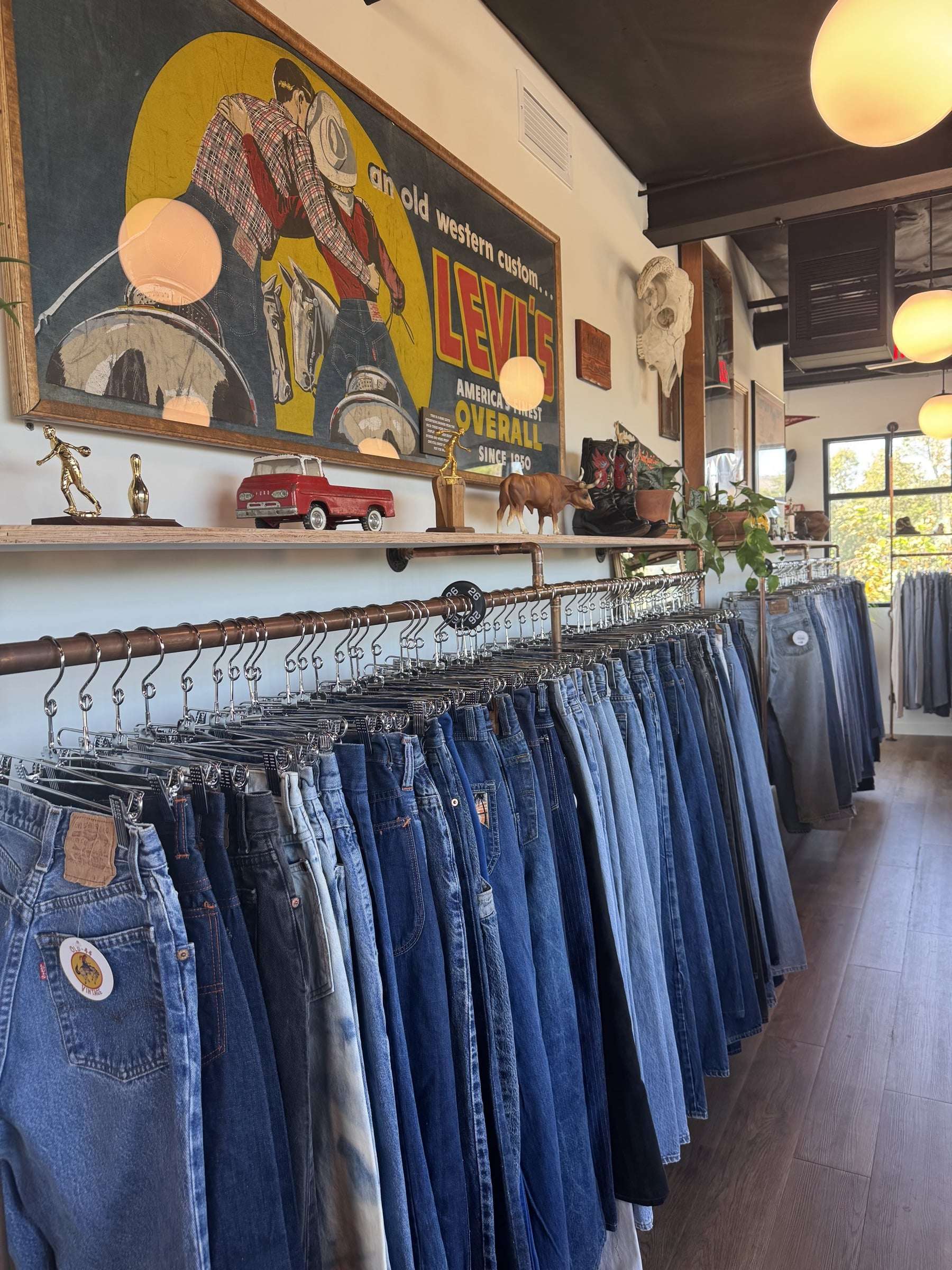 A vintage Levi's advertising banner above a long rail of worn denim inside Old 44 Vintage